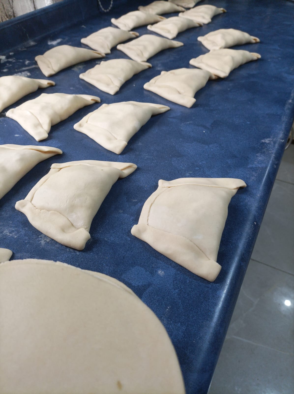Bandeja de empanadas artesanales recién armadas en Ponchelí Empanadería