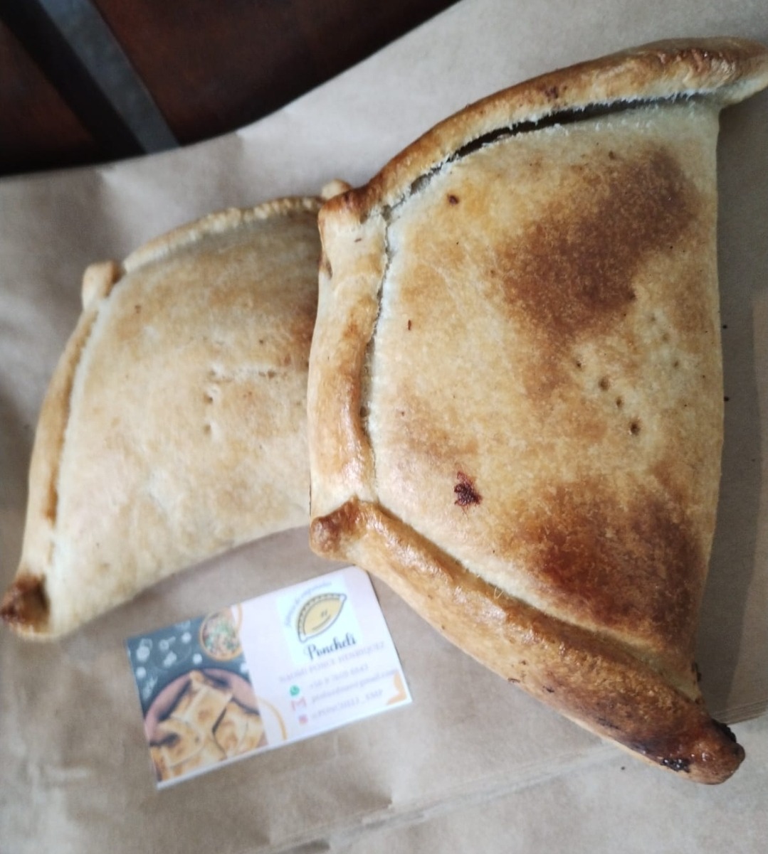 Empanadas Ponchelí sobre papel con tarjeta de la empanadería